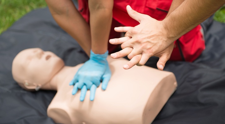 Persona practicando reanimación cardiopulmonar en un maniquí.